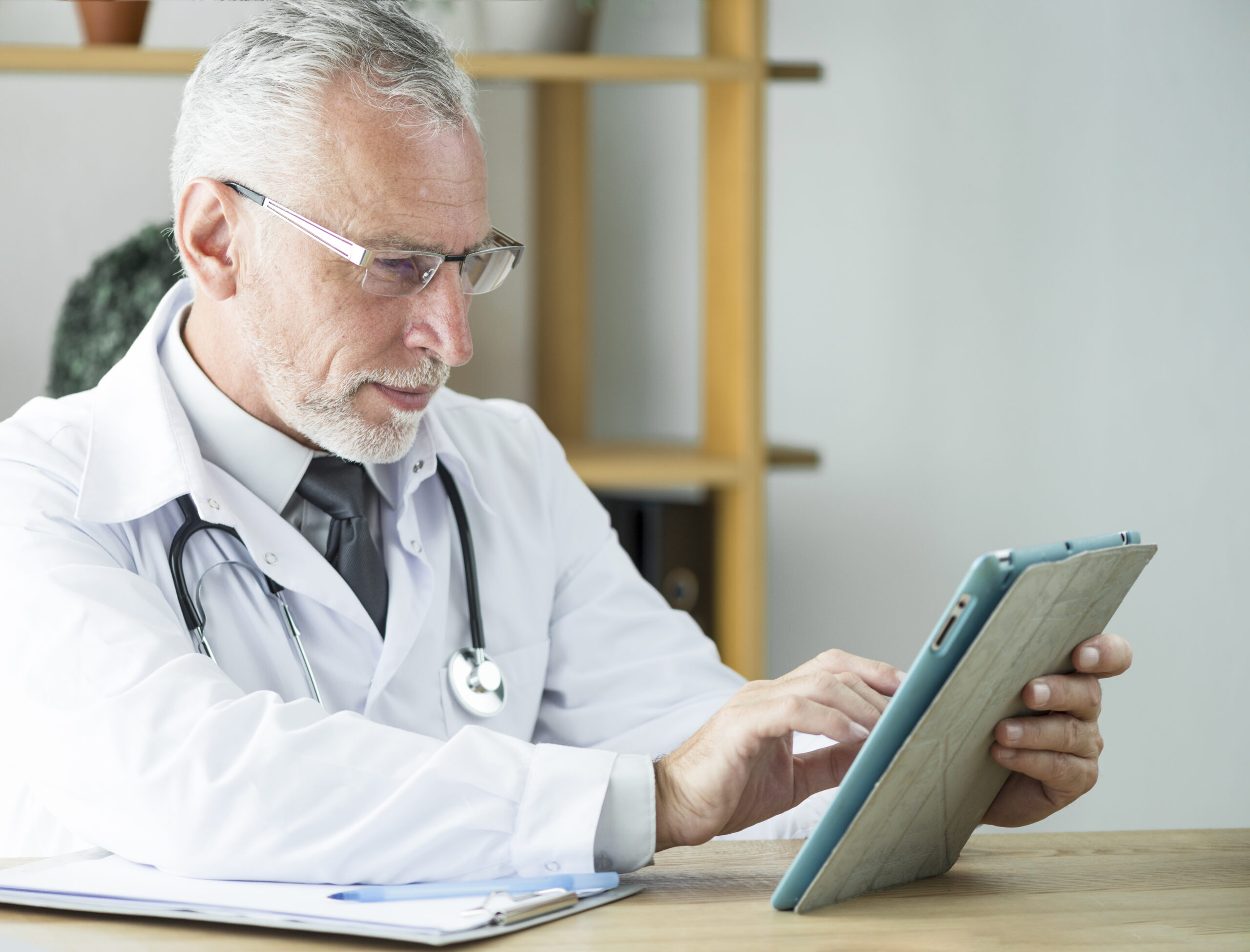 Doctor using tablet to review patient health data from wearables